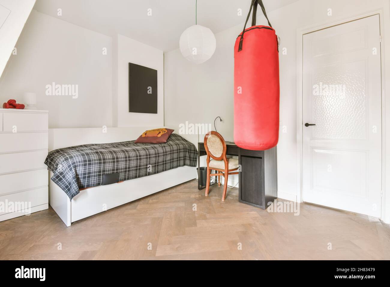 Stylish bedroom with a comfortable bed covered with a checkered duvet and a punching  bag Stock Photo - Alamy