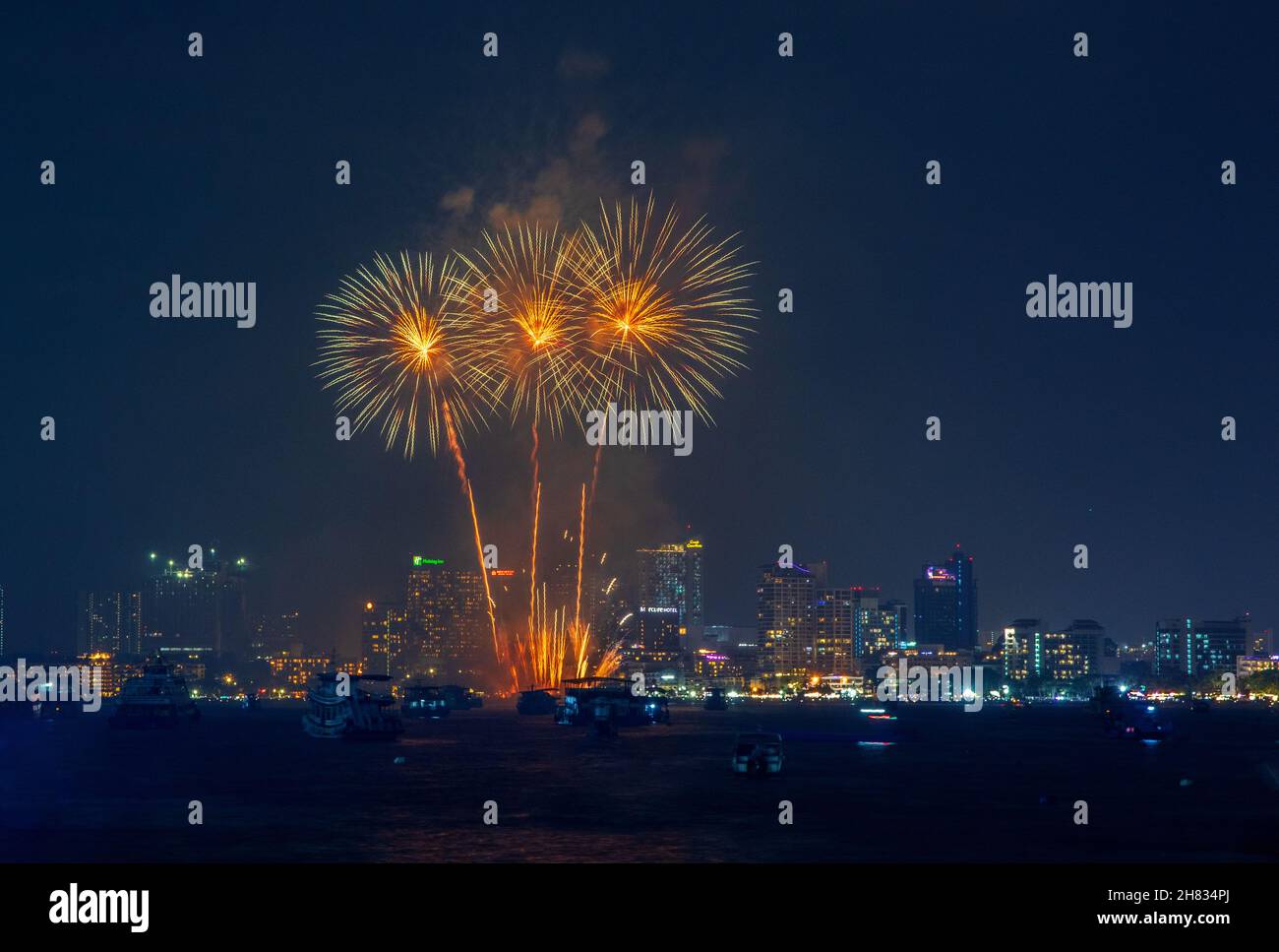 fantastic and colorful fireworks display over the night sky of the city during a festival Stock Photo