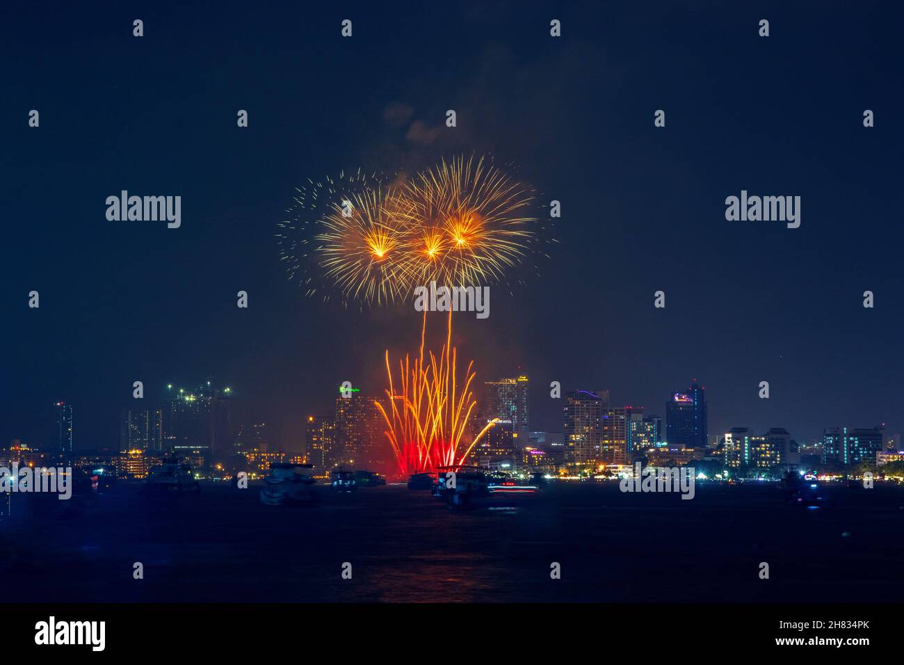 fantastic and colorful fireworks display over the night sky of the city during a festival Stock Photo