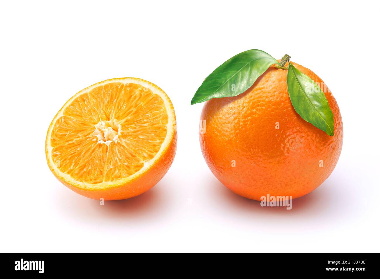 Oranges on white background. One whole with leaves and a half. Stock Photo