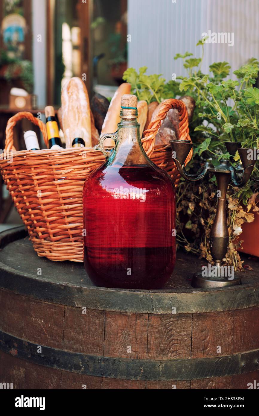 Large Vintage Wine Bottles of red wine standing on a barrel. Old sealed