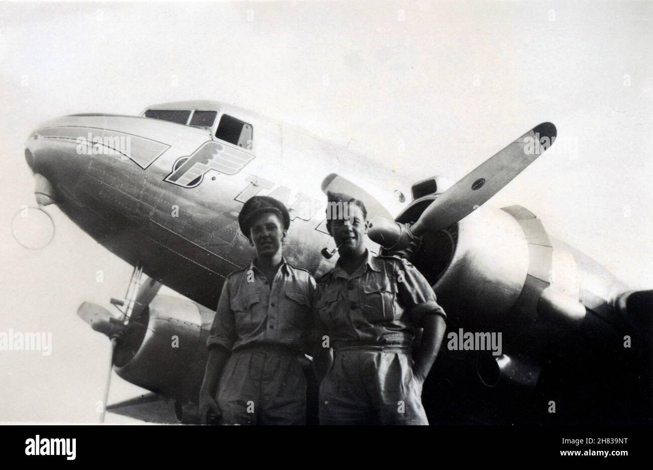 Accra Airport, Ghana, February 1946. RAF pilot officer Browne and sergeant in front of a TAP – Transportes Aéreos Portugueses, DC-3 Dakota. Founded in March 1945, TAP only began commercial flights in September 1946. The flight was probably a test-run for the Linha Aérea Imperial, a twelve-stop colonial service to Angola and Mozambique, which began in December 1946. Stock Photo