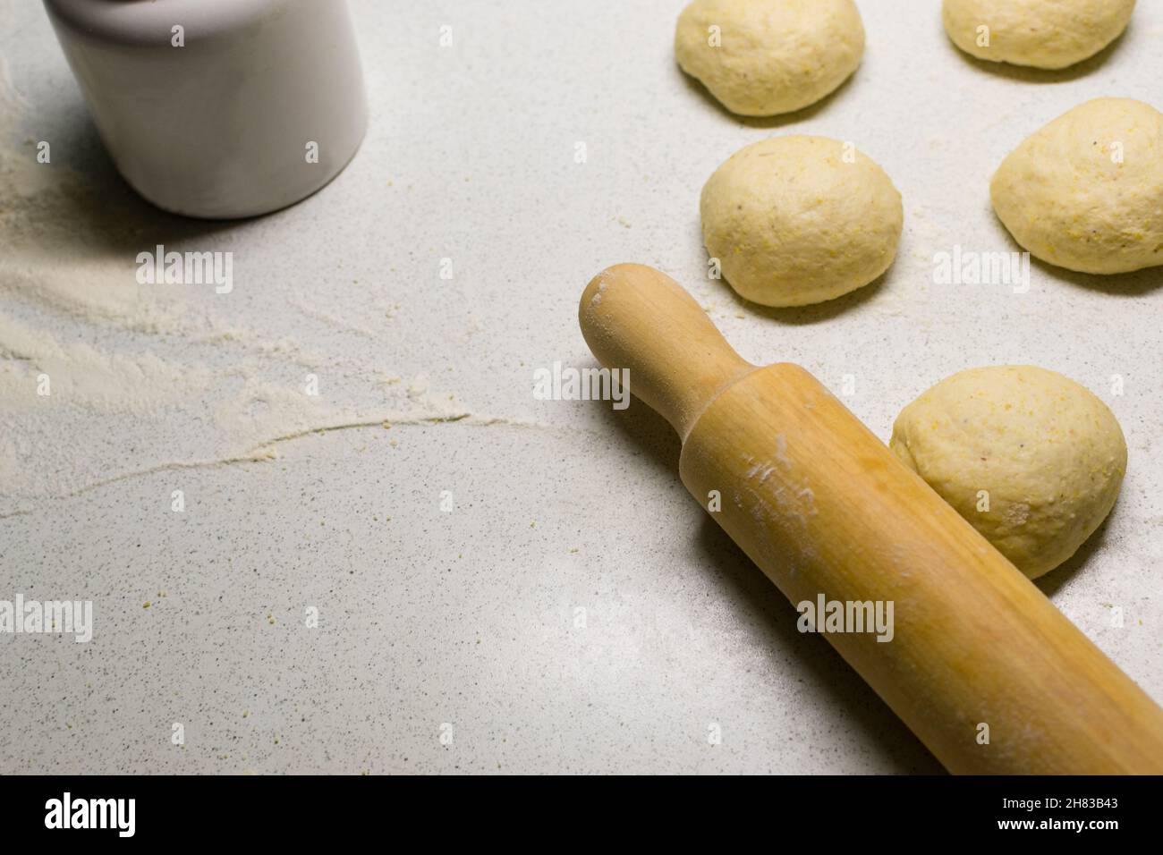 Rolling pin and dough on white kitchen working table, copy space Stock Photo
