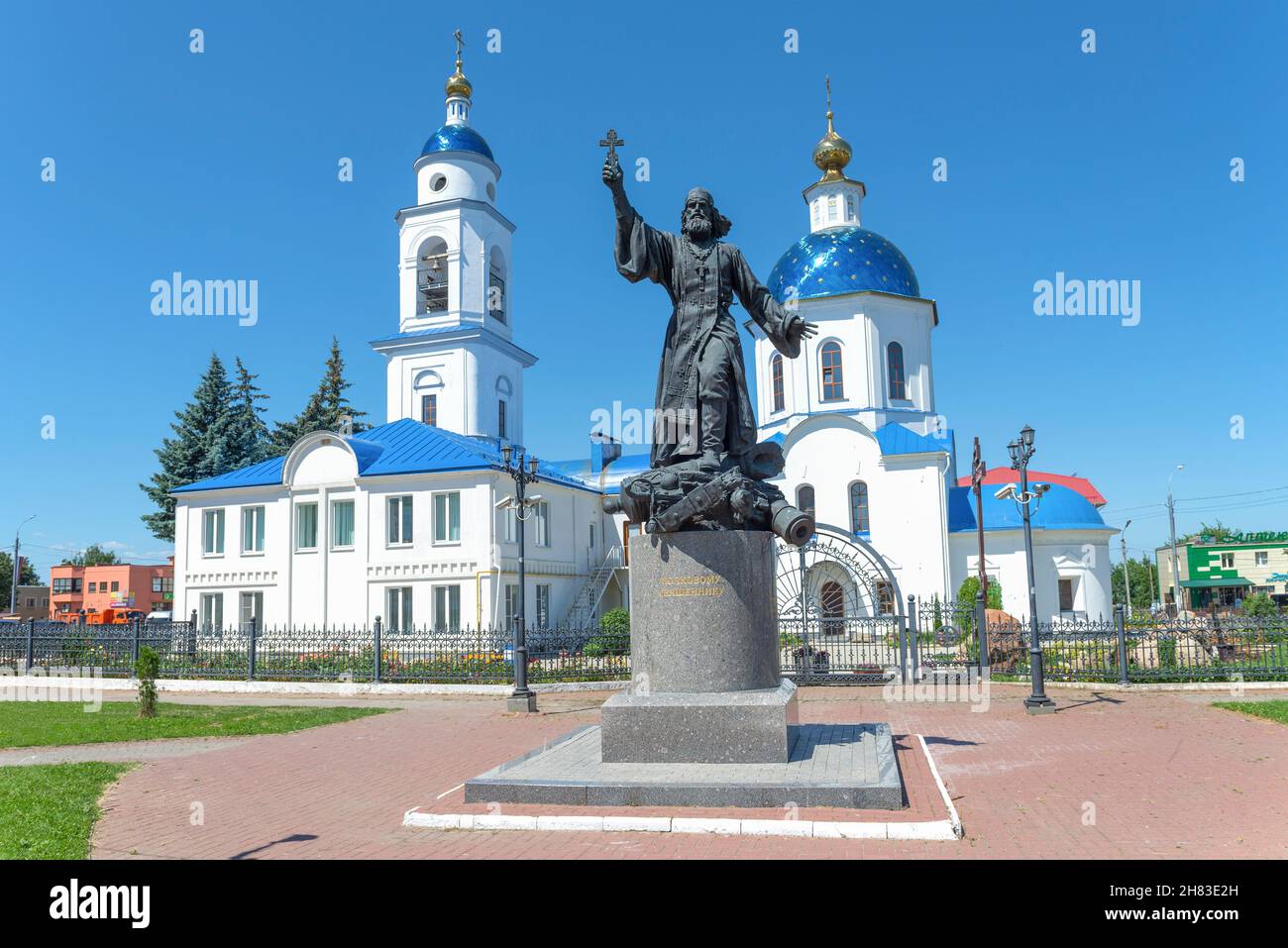 MALOYAROSLAVETS, RUSSIA - JULY 07, 2021: Monument to the regimental priest against the background of the ancient Kazan Cathedral on a sunny July day Stock Photo