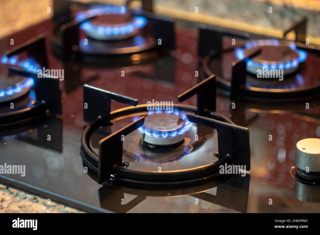 The gas burns in the burner of a kitchen stove. Horizontal view Stock