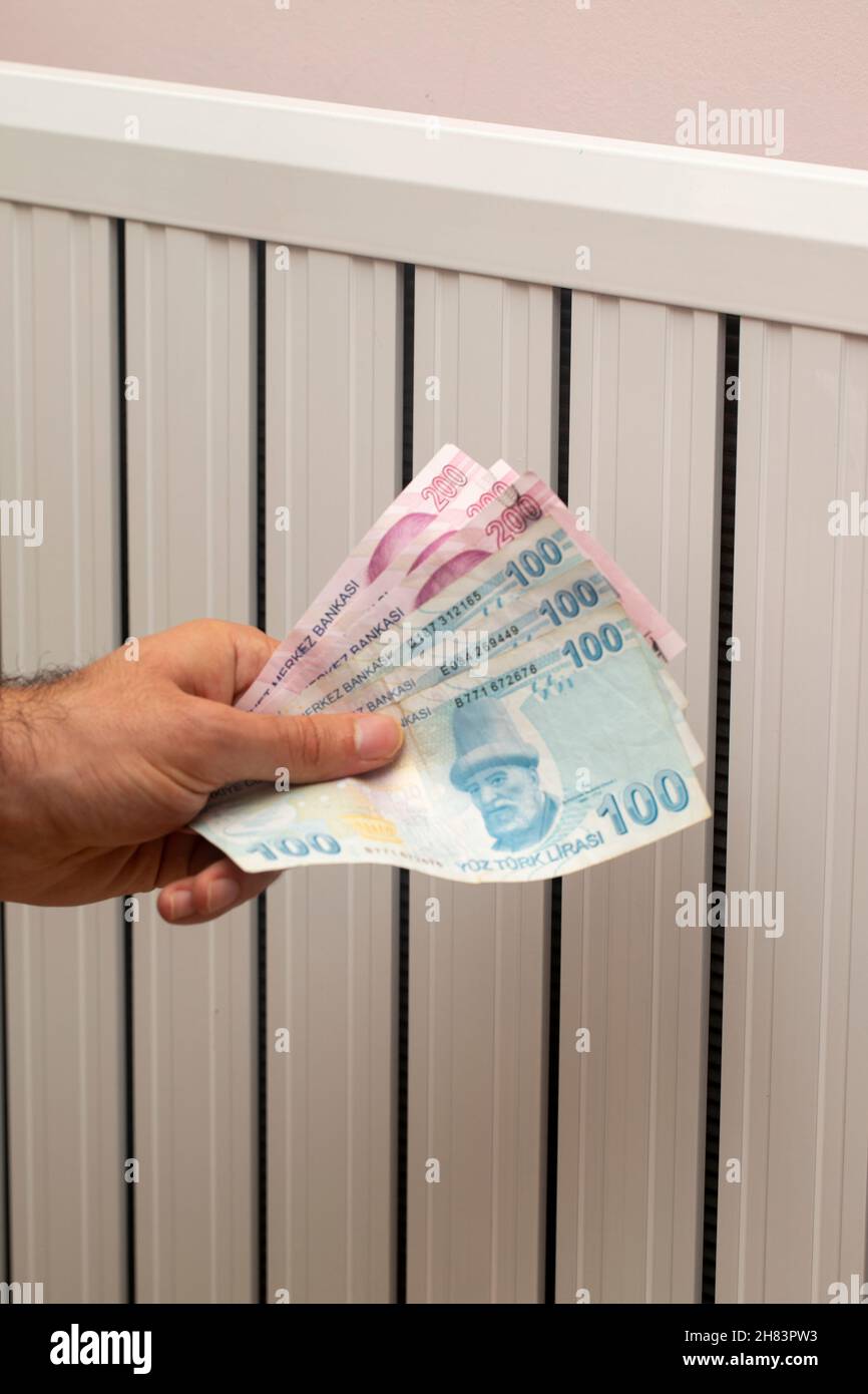 Turkey energy crisis. increase in gas prices in Europe for the population. Turkish lira in front of a burning radiator Stock Photo