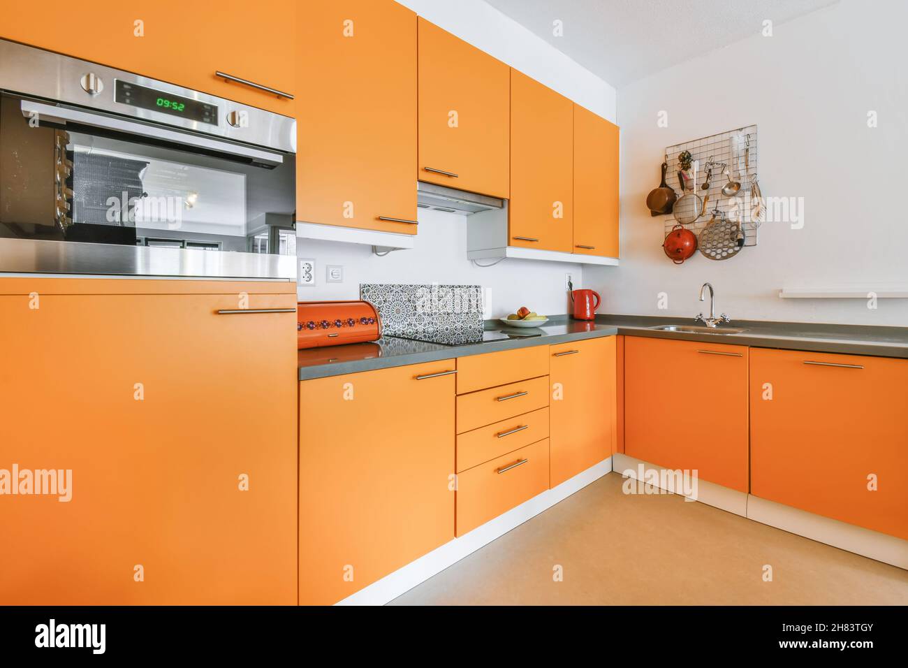 Stylish kitchen design with orange kitchen set Stock Photo Alamy