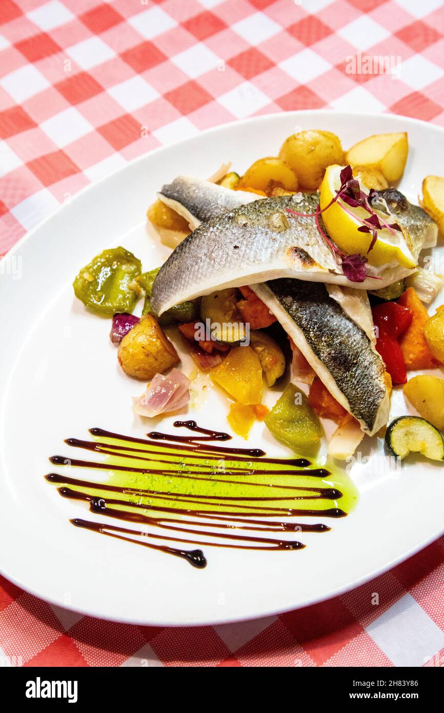 Sea bass fillets, mediterranean vegetables and new potatoes at The Mermaid seafood restaurant, St Ives, Cornwall, UK Stock Photo