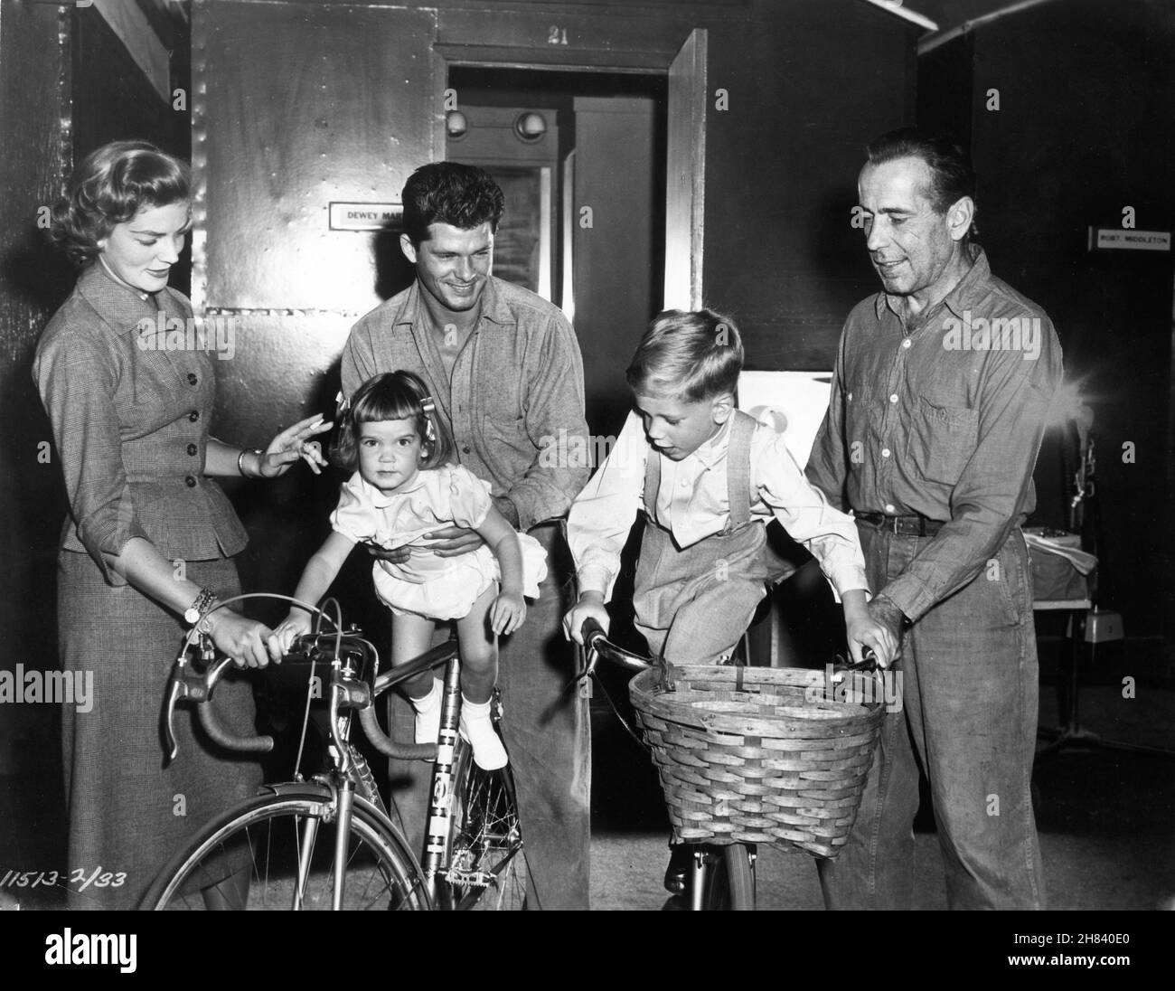 HUMPHREY BOGART and his Wife LAUREN BACALL on set candid with their two children daughter LESLIE and son STEPHEN with DEWEY MARTIN outside dressing room during filming of THE DESPERATE HOURS 1955 director WILLIAM WYLER novel / play / screenplay Joseph Hayes cinematographer Lee Garmes costumer Edith Head Paramount Pictures Stock Photo