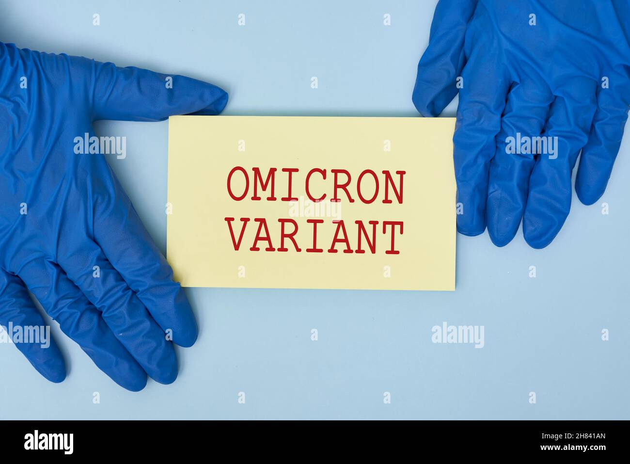 Doctor hand holds a card with text - New covid variant Omicron. Covid-19 new variant - Omicron. Omicron variant of coronavirus. SARS-CoV-2 variant of Stock Photo