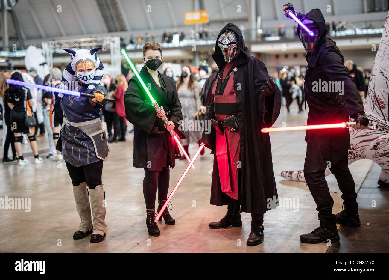 Stuttgart, Germany. 27th Nov, 2021. Visitors to the Comic and Fantasy Fair in the German city of Stuttgart come to the fairgrounds dressed as characters from the 'Star Wars' film saga, wearing protective masks, one of the requirements against the coronavirus to gain access to the event. Credit: Christoph Schmidt/dpa/Alamy Live News Stock Photo