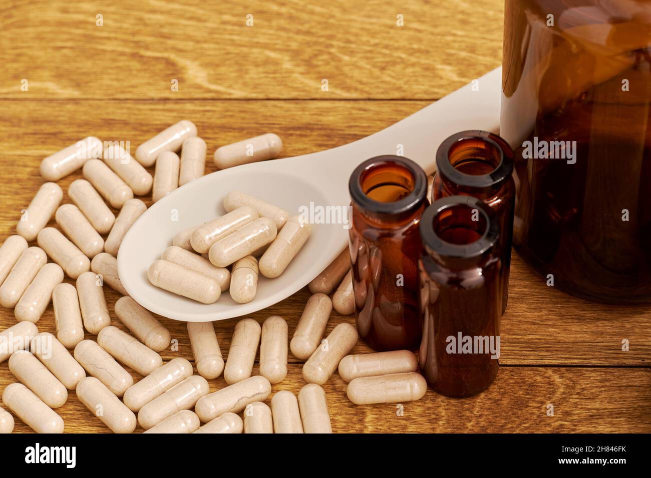Spoon overdose with an overdose of diet pills on the wooden table. Drug obsession concept Stock Photo