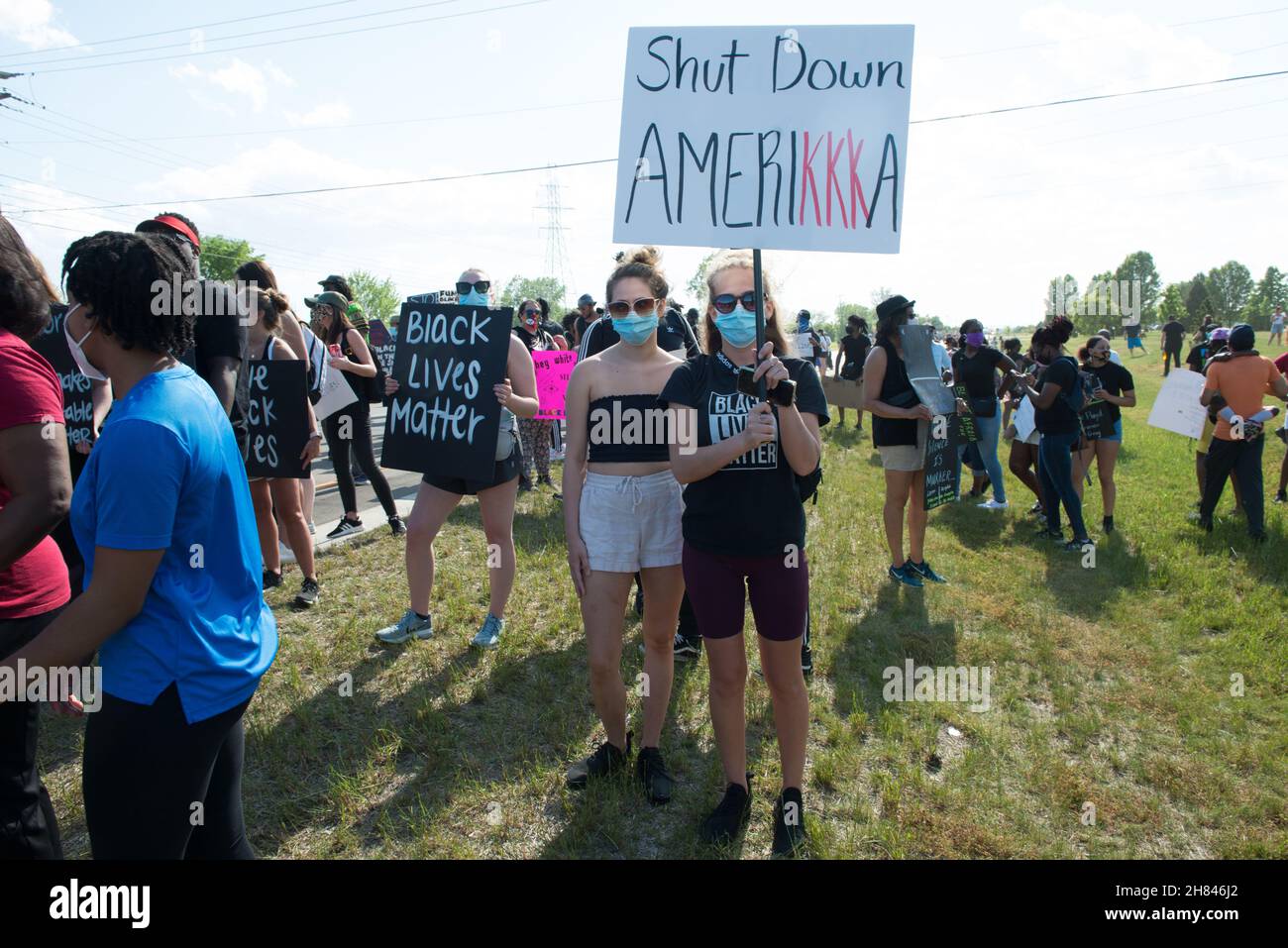 Two women holding a sign 'Shut Down AmeriKKKa' at the BLM protest in Sterling Heights, Michigan, June 6, 2020. Stock Photo