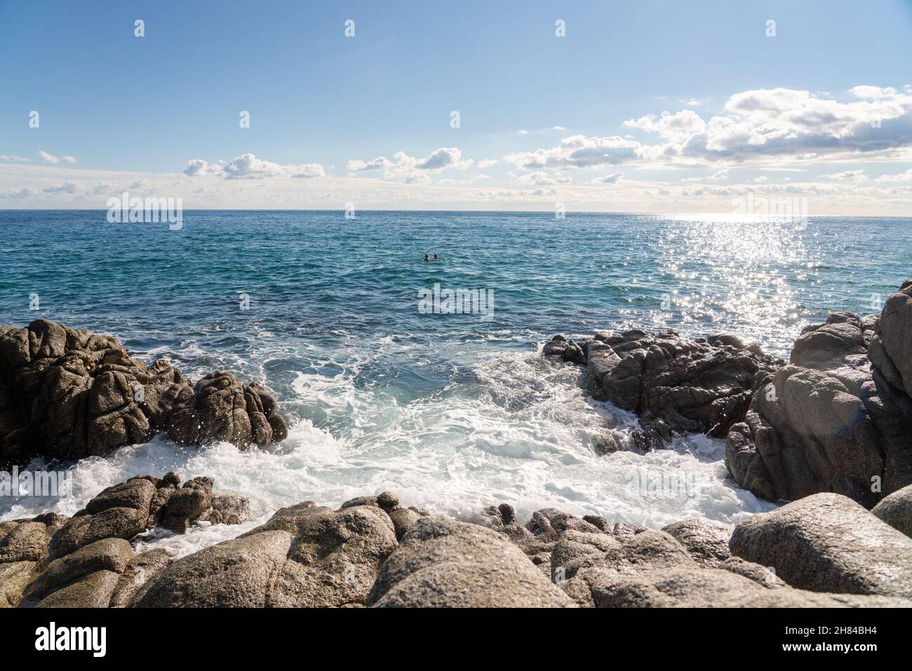 waves splashes on rock in sea shore, pretty calm sea with blue sky and some clouds Stock Photo