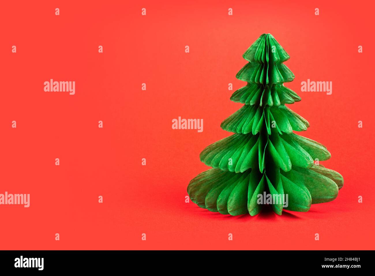 Green christmas tree on red background Stock Photo - Alamy