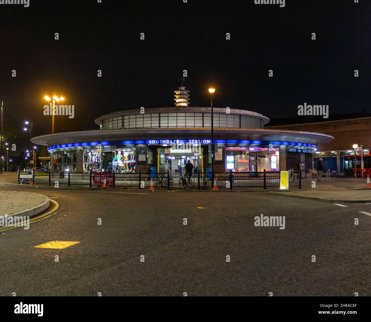 A night shot of Southgate tube station with the road in the foreground. The station is an Art Deco station designed by Charles holden. Piccadilly line Stock Photo