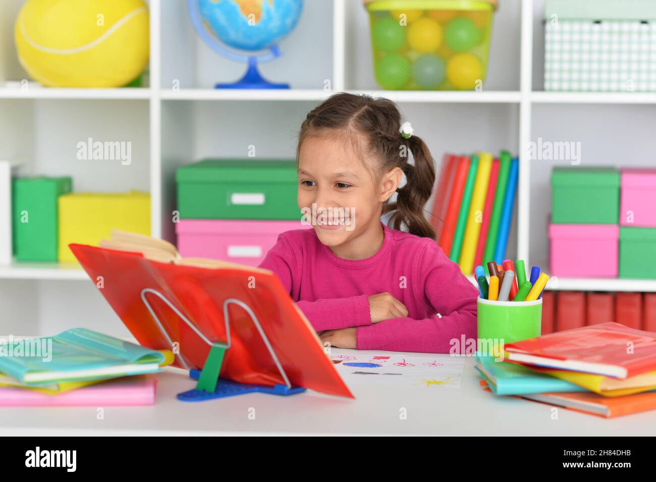 Porait of cute little girl studying at home Stock Photo - Alamy