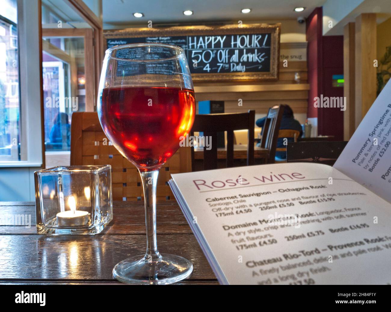 ROSÉ WINE GLASS BAR MENU HAPPY HOUR One Glass of rosé wine, wine list and candle, with