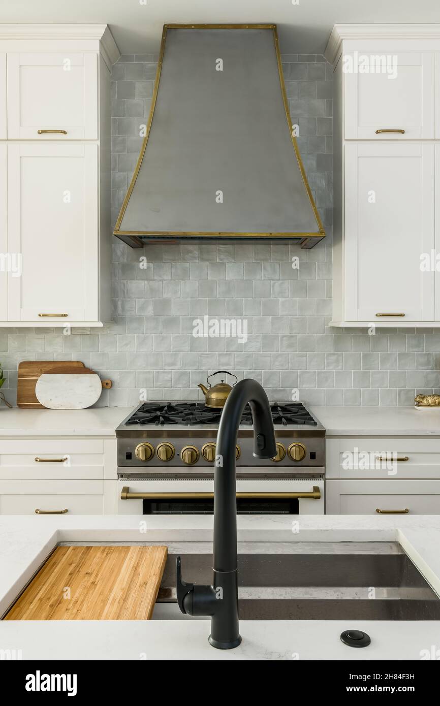 Modern White Kitchen with Shaker Cabinets, Granite Counters, Gray Backsplash, and Modern Appliances Interior Design Stock Photo