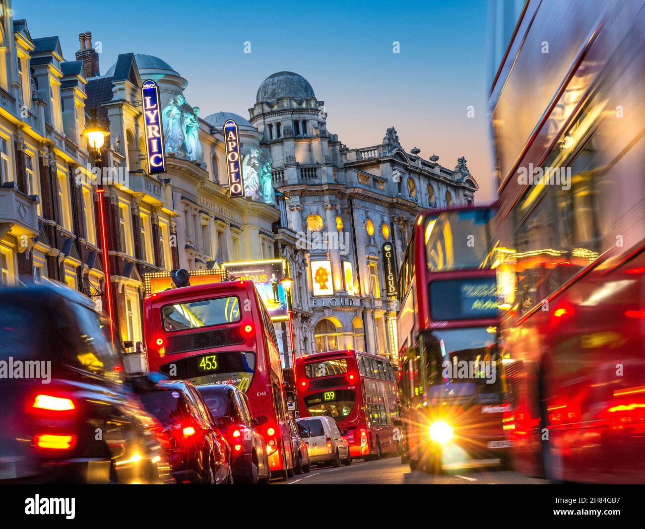 SHAFTESBURY AVENUE GRIDLOCK NIGHT LONDON TRAFFIC BUSES CARS VANS  ULEZ POLLUTION  Theatreland West End Lyric Apollo theatres busy heavy pollution diesel fumes with red buses taxis and private vehicles in Shaftesbury Avenue at dusk West End London UK Stock Photo