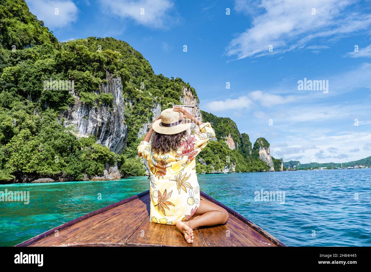 Maya Bay Koh Phi Phi Thailand, Turquoise clear water Thailand Koh Pi Pi,  Scenic aerial view of Koh Phi Phi Island in Thailand. Asian woman mid age  with hat in longtail boat