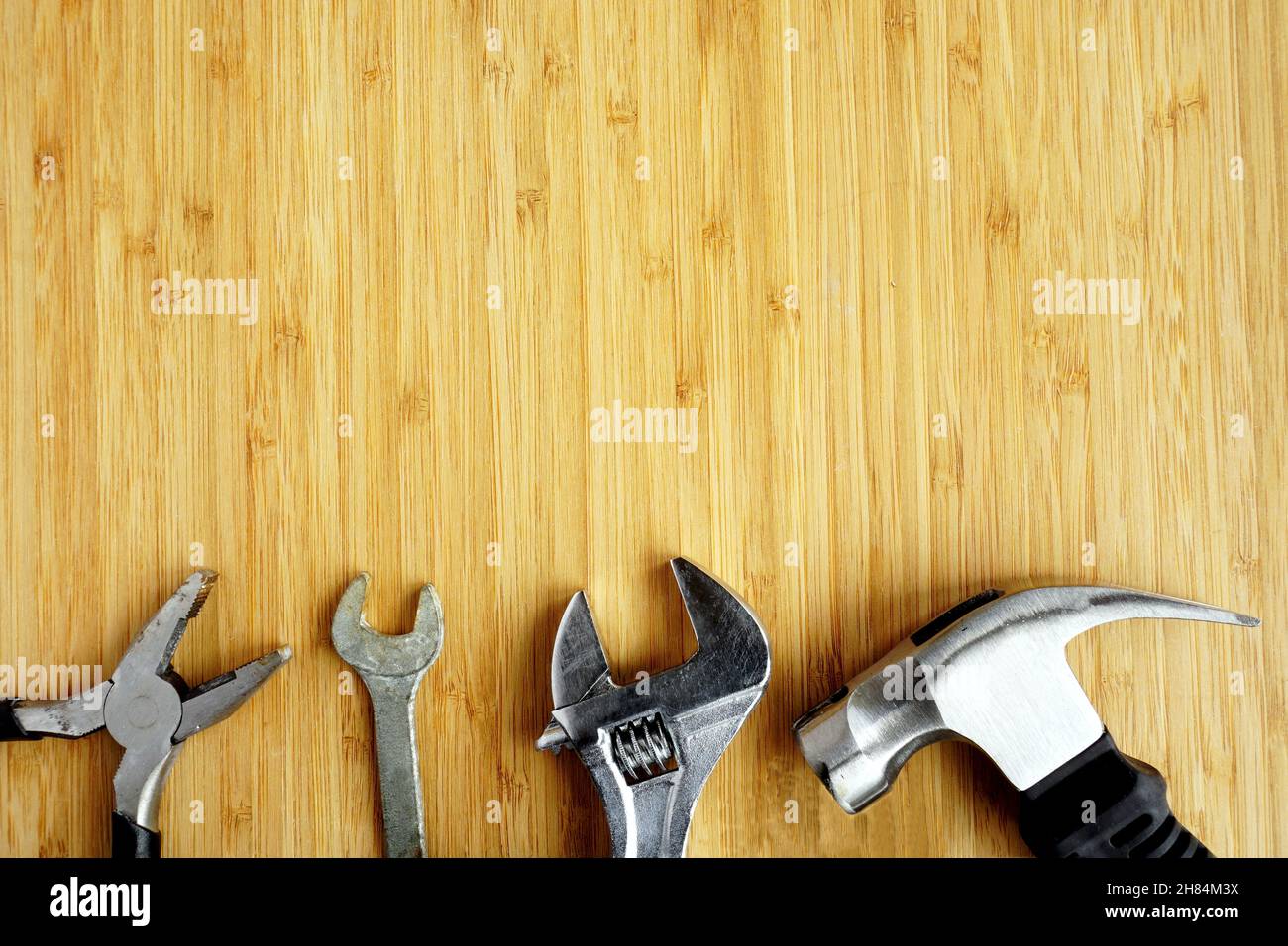 Pliers, spanner, adjustable wrench and hammer on workbench Stock Photo