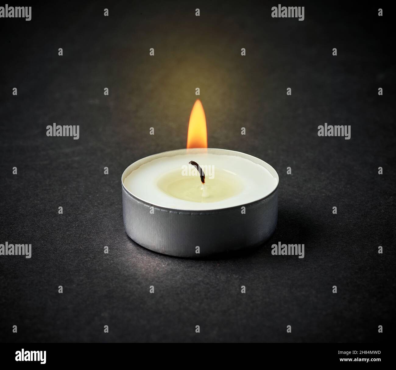 beautiful burning candle on black table background Stock Photo - Alamy