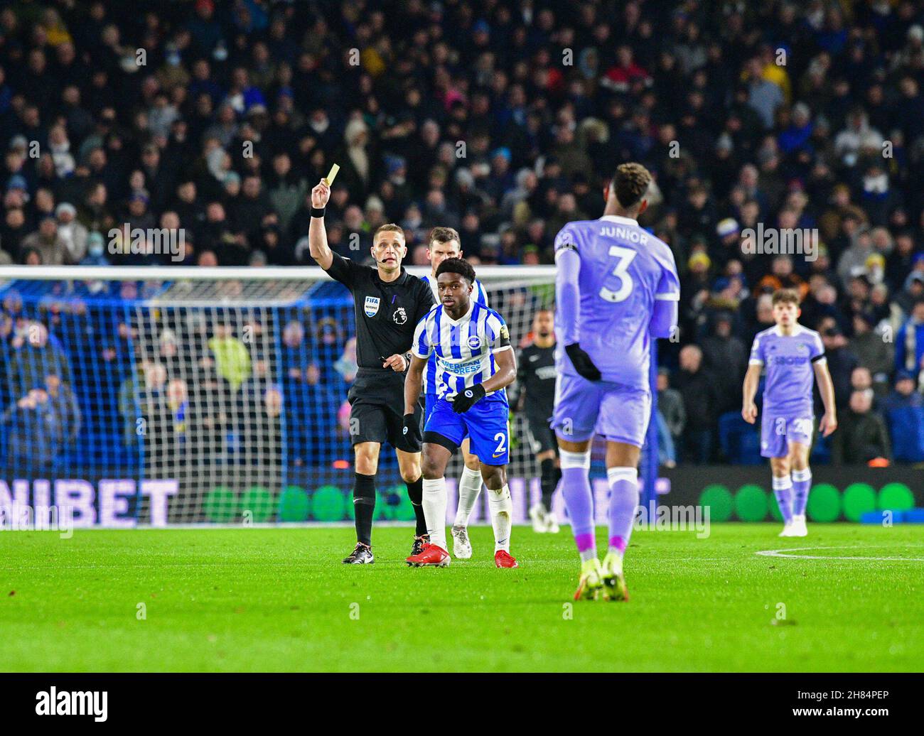 Brighton, UK. 27th Nov, 2021. Junior Firpo of Leeds United is shown a yellow card for his fould on Tariq Lamptey of Brighton and Hove Albion during the Premier League match between Brighton & Hove Albion and Leeds United at The Amex on November 27th 2021 in Brighton, England. (Photo by Jeff Mood/phcimages.com) Credit: PHC Images/Alamy Live News Stock Photo