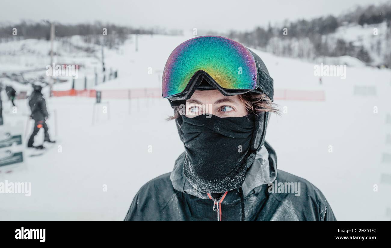 Ski portrait. Iced up frozen ski goggles and ski helmet on man looking at camera with ski goggles icing up in freeze. Concept of Glaze ice, also Stock Photo