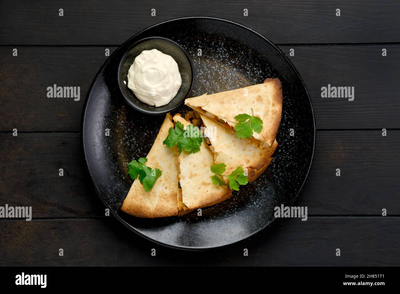 Top view of quesadilla with chicken meat, cheese and pickled cucumber