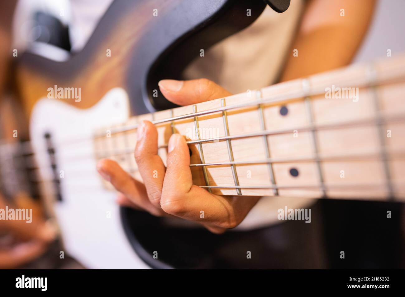close up of a bassist's hand with tapping technique playing electric
