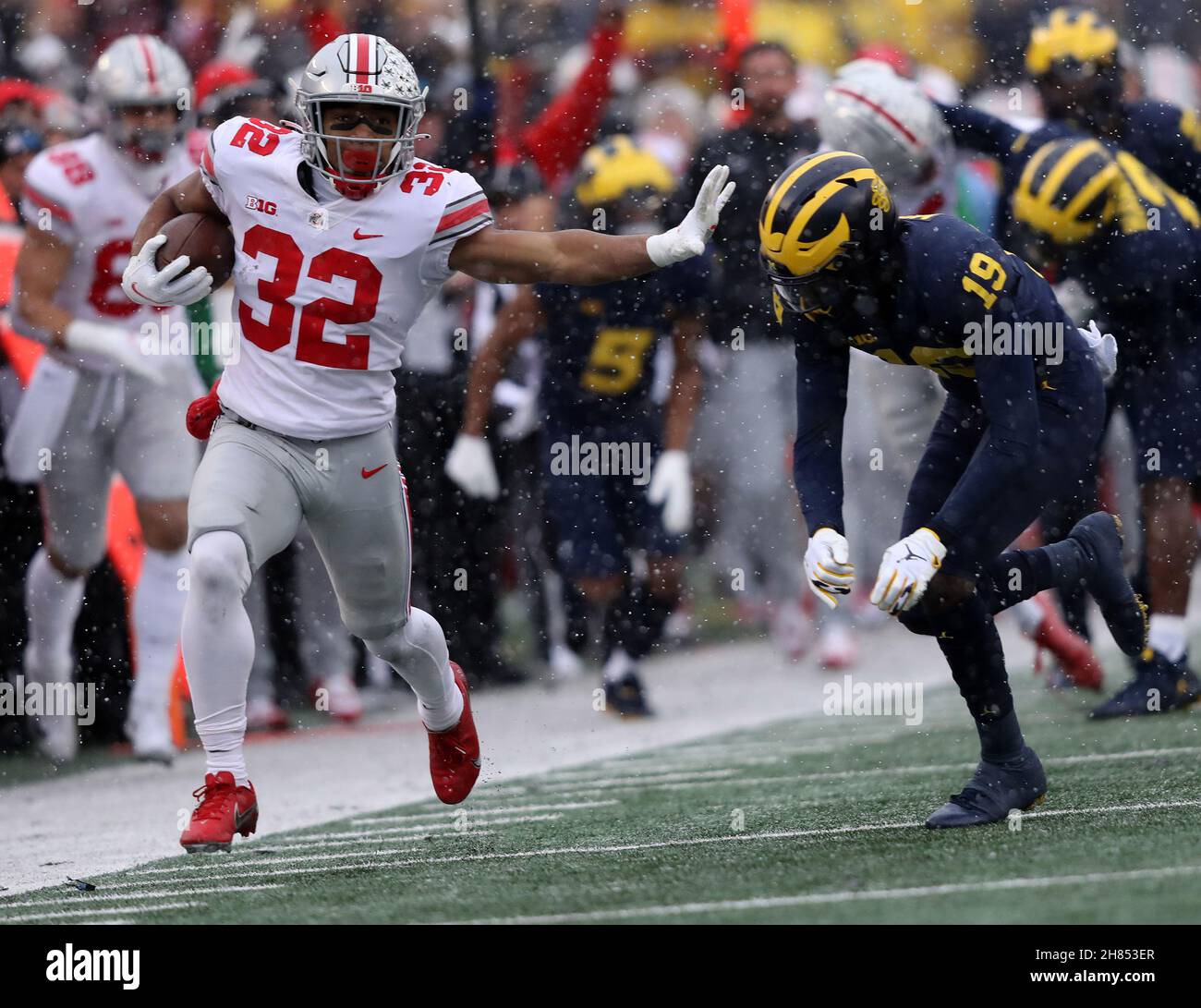 Ann Arbor, United States. 27th Nov, 2021. Ohio State Buckeyes TreVeyon Henderson (32) still arms Michigan Wolverine Rod Moore (19) on a run in the first in Ann Arbor, Michigan on Saturday, November 27, 2021. Photo by Aaron Josefczyk/UPI Credit: UPI/Alamy Live News Stock Photo