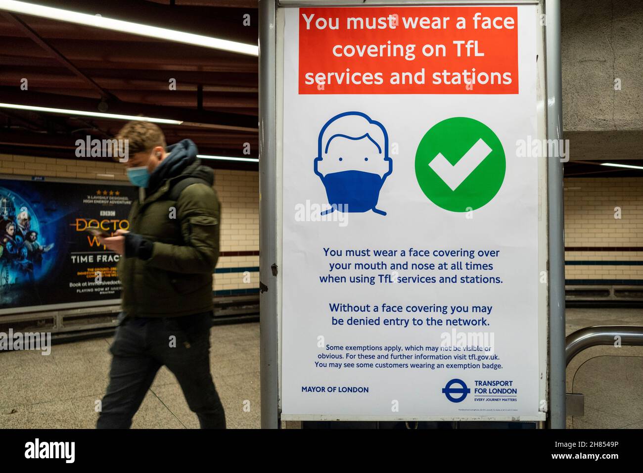London, UK.  27 November 2021.  People at Baker Street station pass a sign requiring the wearing of facemasks. Boris Johnson, Prime Minister, has announced in a press conference measures to curb the spread of coronavirus in the UK in response to two cases of the Omicron variant being detected in the country.  Measures include mandatory wearing of facemasks in shops and public transport as well as PCR test for travellers entering the UK.  Credit: Stephen Chung / Alamy Live News Stock Photo