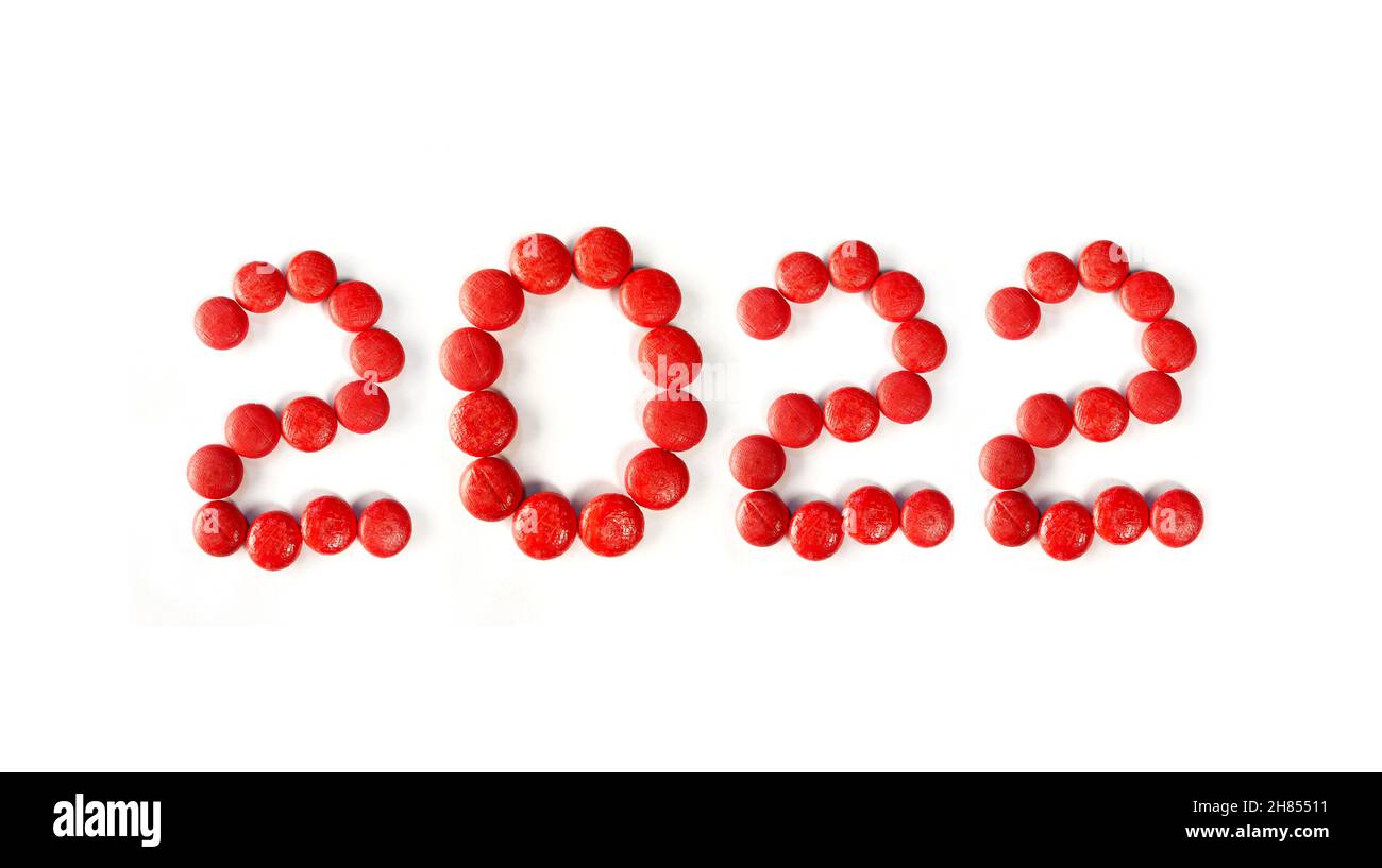2022 concept with red wooden ball or round object. writing 2022 on white paper Stock Photo