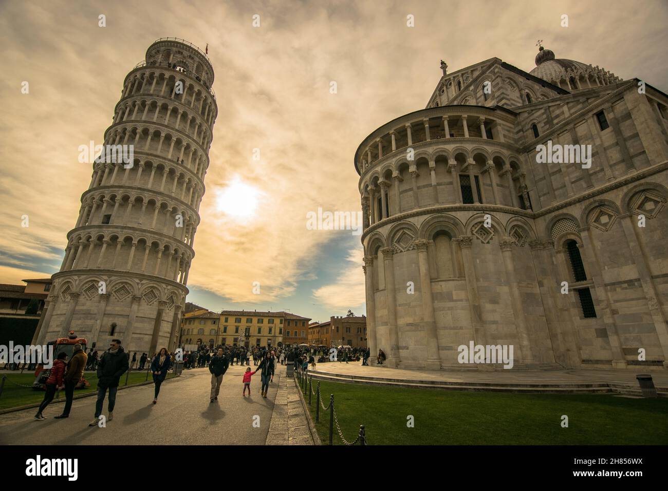 A beautiful day in Pisa, Italy. In the background many tourists enjoying the leaning tower. Campo dei Miracoli. Stock Photo