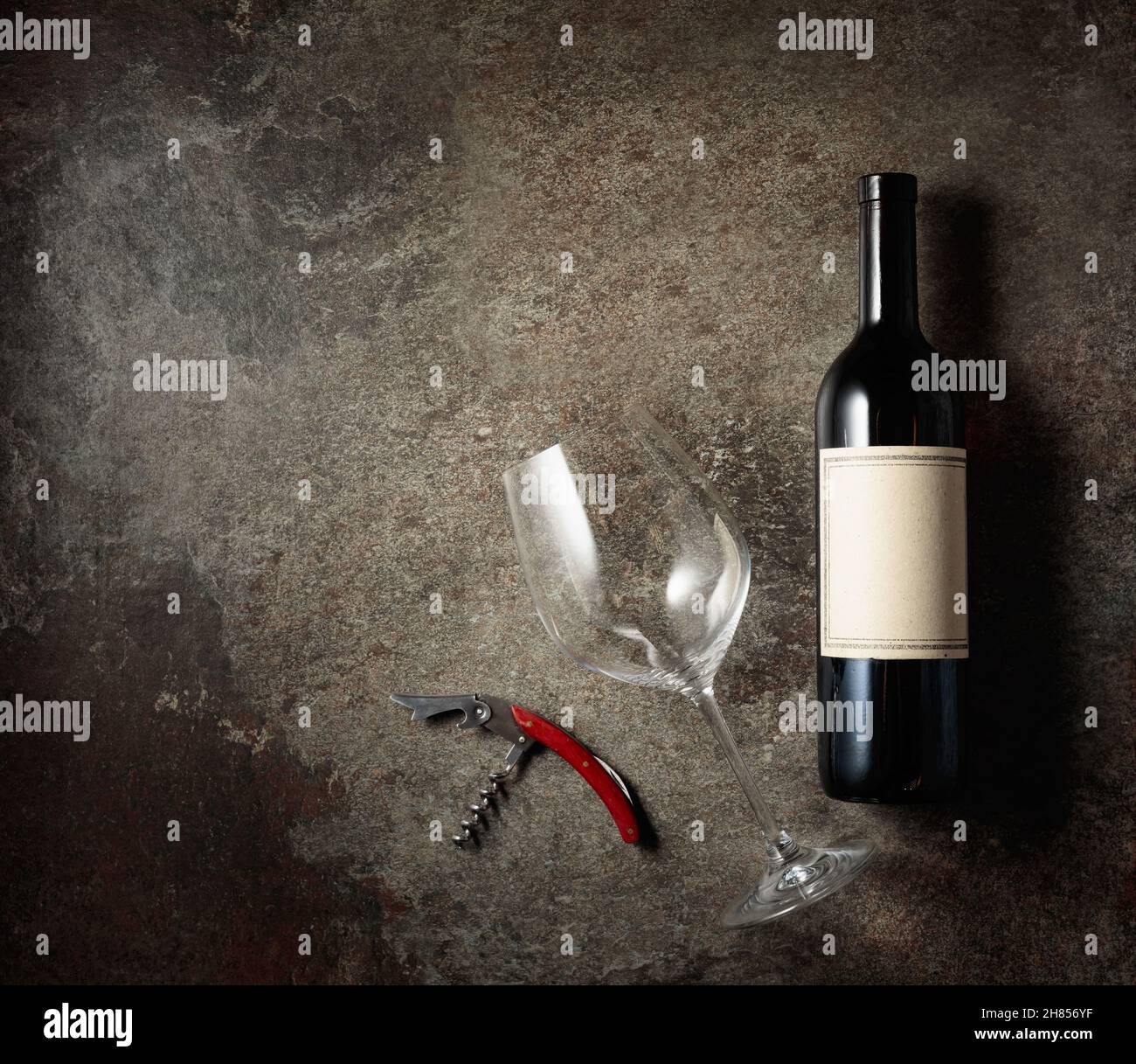 Red wine on an old rough background. Bottle with an old empty label