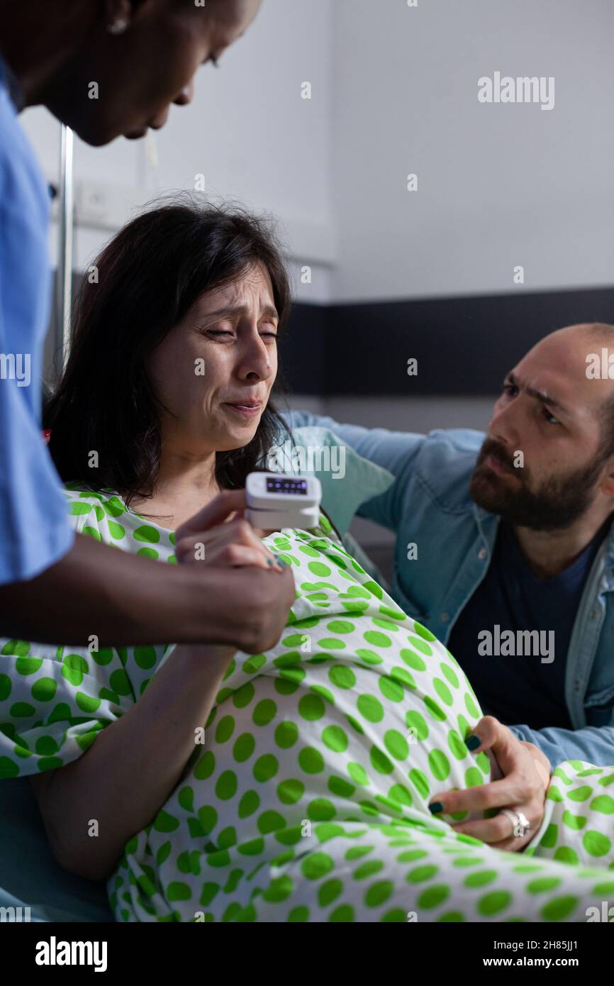 https://c8.alamy.com/comp/2H85JJ1/close-up-of-pregnant-person-with-painful-contractions-holding-hand-of-nurse-and-man-in-hospital-ward-young-woman-getting-into-labor-while-having-medical-assistance-at-facility-2H85JJ1.jpg