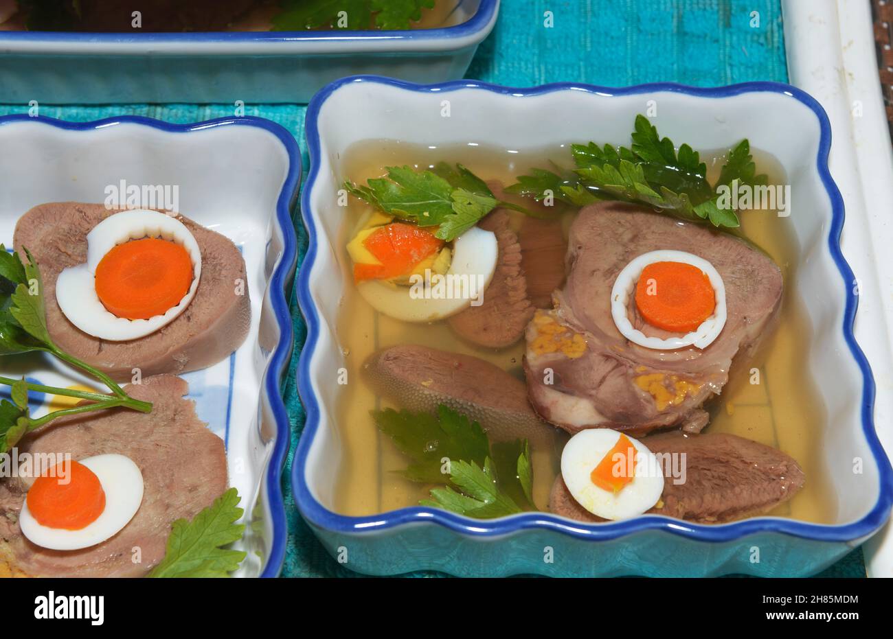 Jelly broth is pouring from ladle spoon in mold with ingredients of