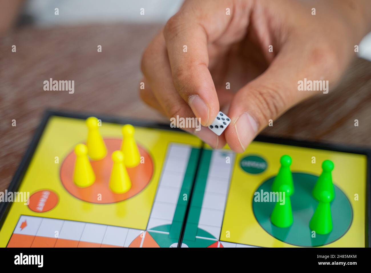 Close up of hand holding dice while playing ludo Stock Photo
