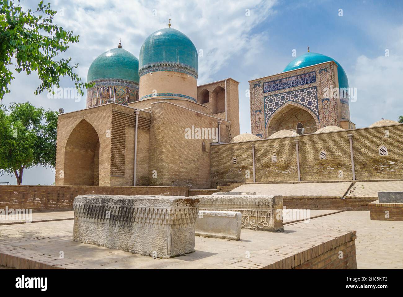 Sheikh Kulal Mausoleum and Kok Gumbaz Mosque in Shakhrisabz, Uzbekistan. In foreground are medieval tombstones, also part of Dorut Tilavat complex. Fa Stock Photo