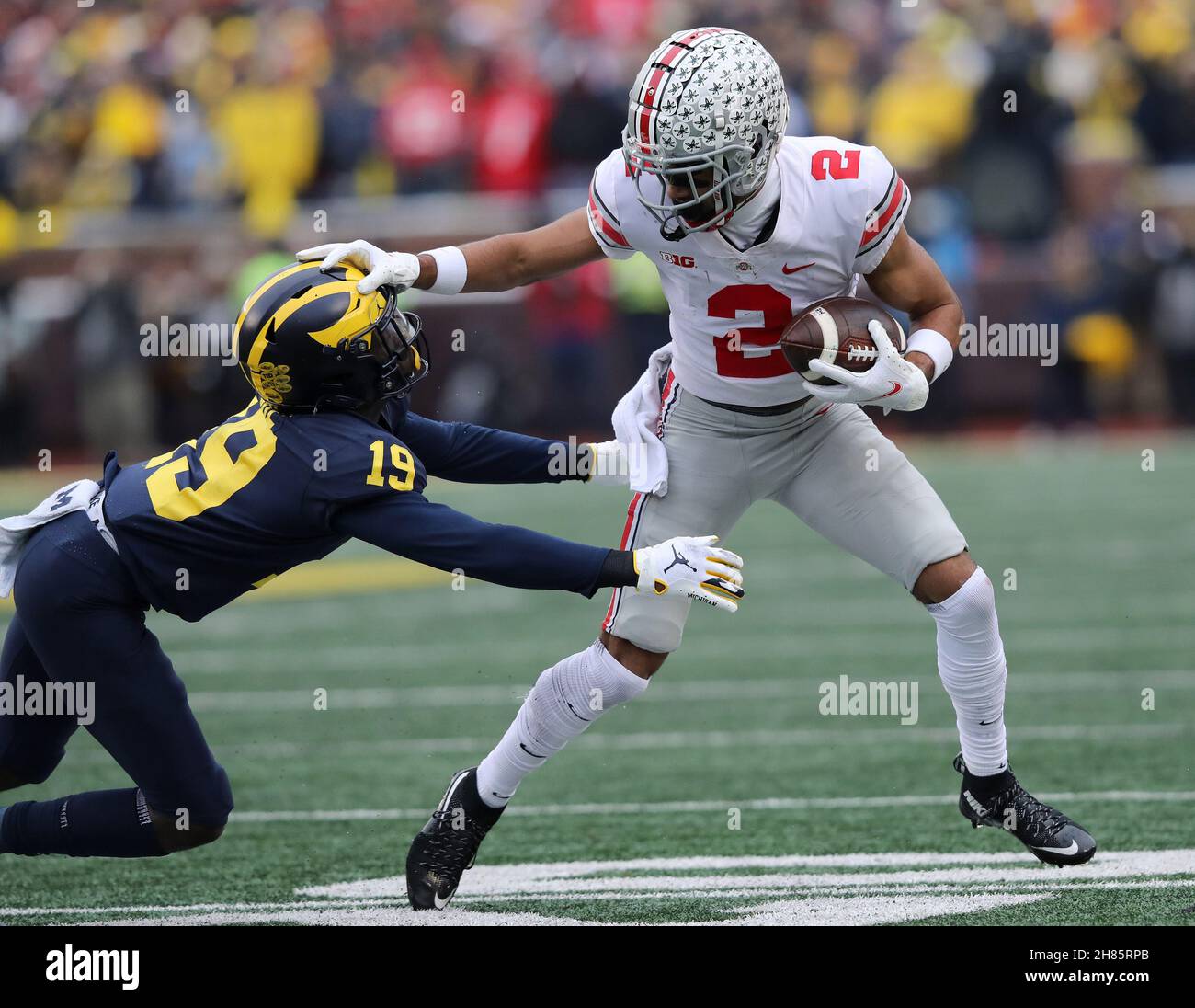 Ann Arbor, United States. 27th Nov, 2021. Ohio State Buckeyes Chris Olave (2) stiff arms Michigan Wolverines Rod Moore (19) on a run after a catch in Ann Arbor, Michigan on Saturday, November 27, 2021. Photo by Aaron Josefczyk/UPI Credit: UPI/Alamy Live News Stock Photo