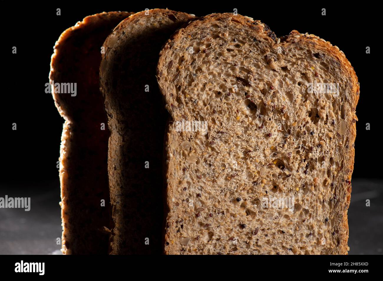 Detailed close up of high fibre low GI seven seeds and grain bread in low key lighting Stock