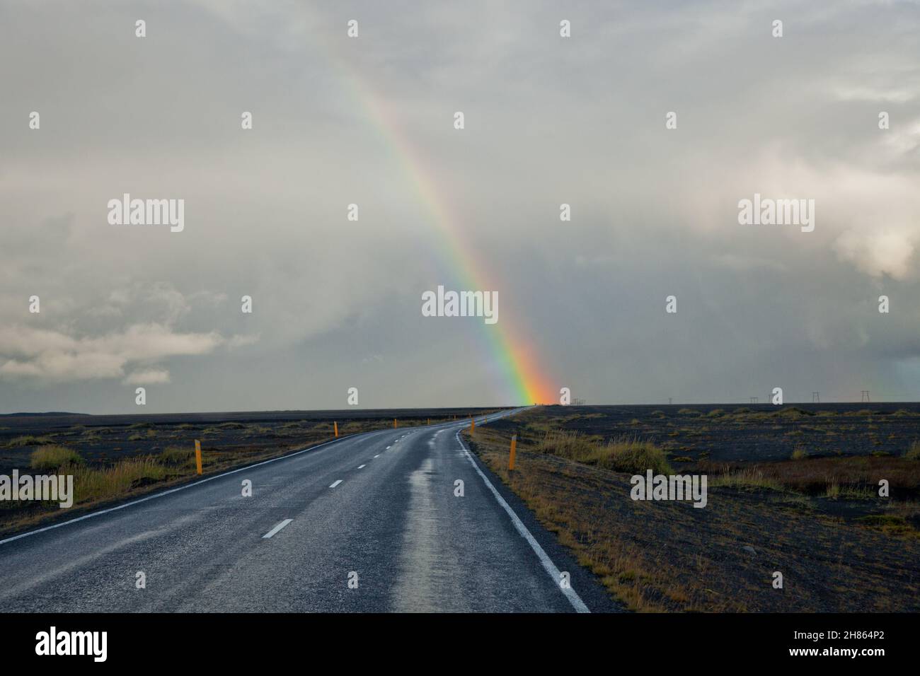 A rainbow over a long rural road in Iceland Stock Photo - Alamy