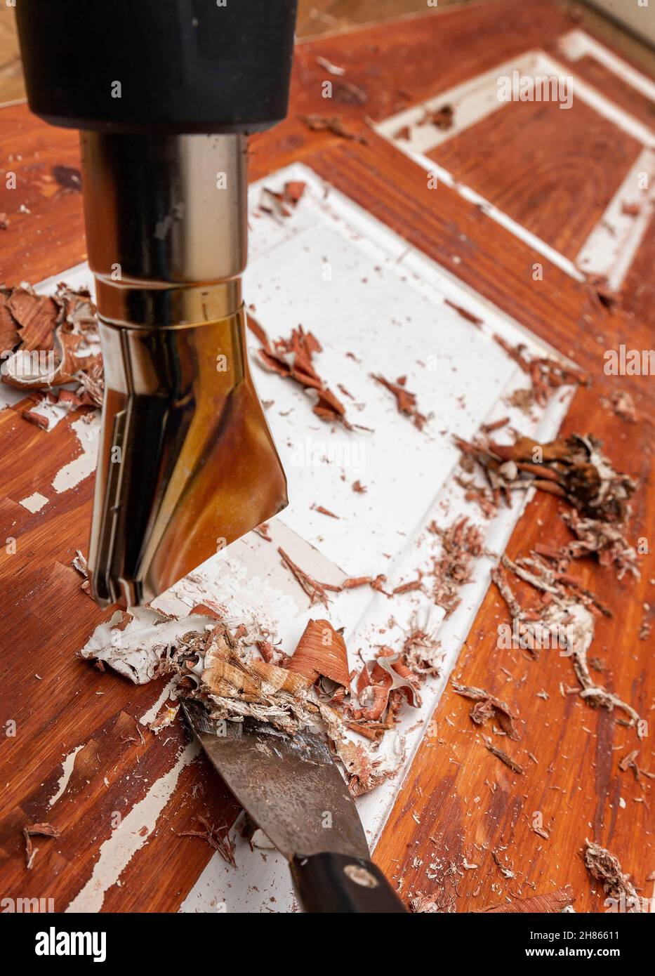 Stripping paint off a 6panel wooden door using a heat gun and scraper Stock Photo Alamy