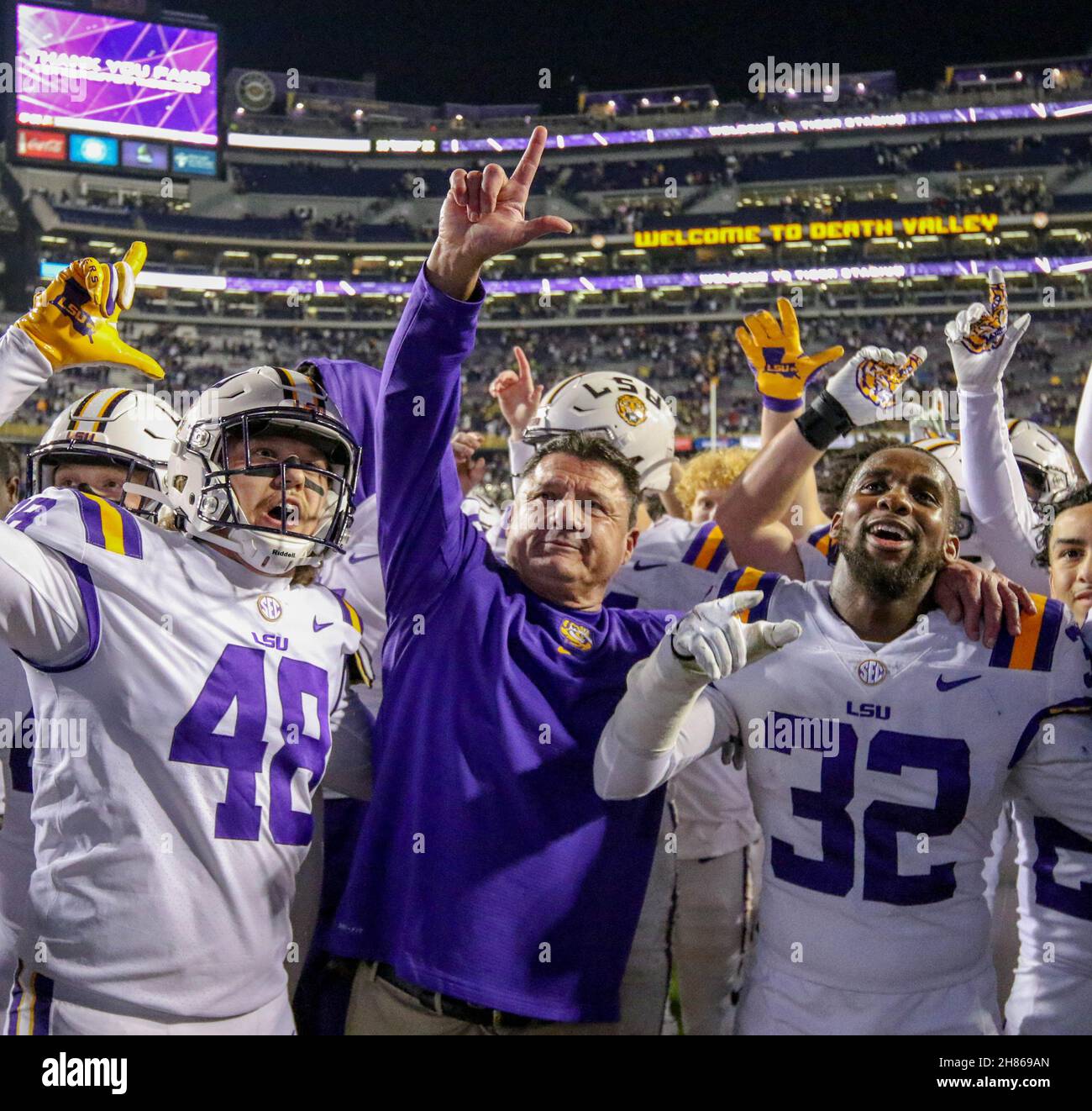 Baton Rouge, LA, USA. 27th Nov, 2021. LSU Head Coach Ed Orgeron leads the team in the LSU Alma Mater with players Sloan Wright (48), and Lloyd Cole (32) after NCAA football game action between the Texas A&M Aggies and the LSU Tigers at Tiger Stadium in Baton Rouge, LA. Jonathan Mailhes/CSM/Alamy Live News Stock Photo
