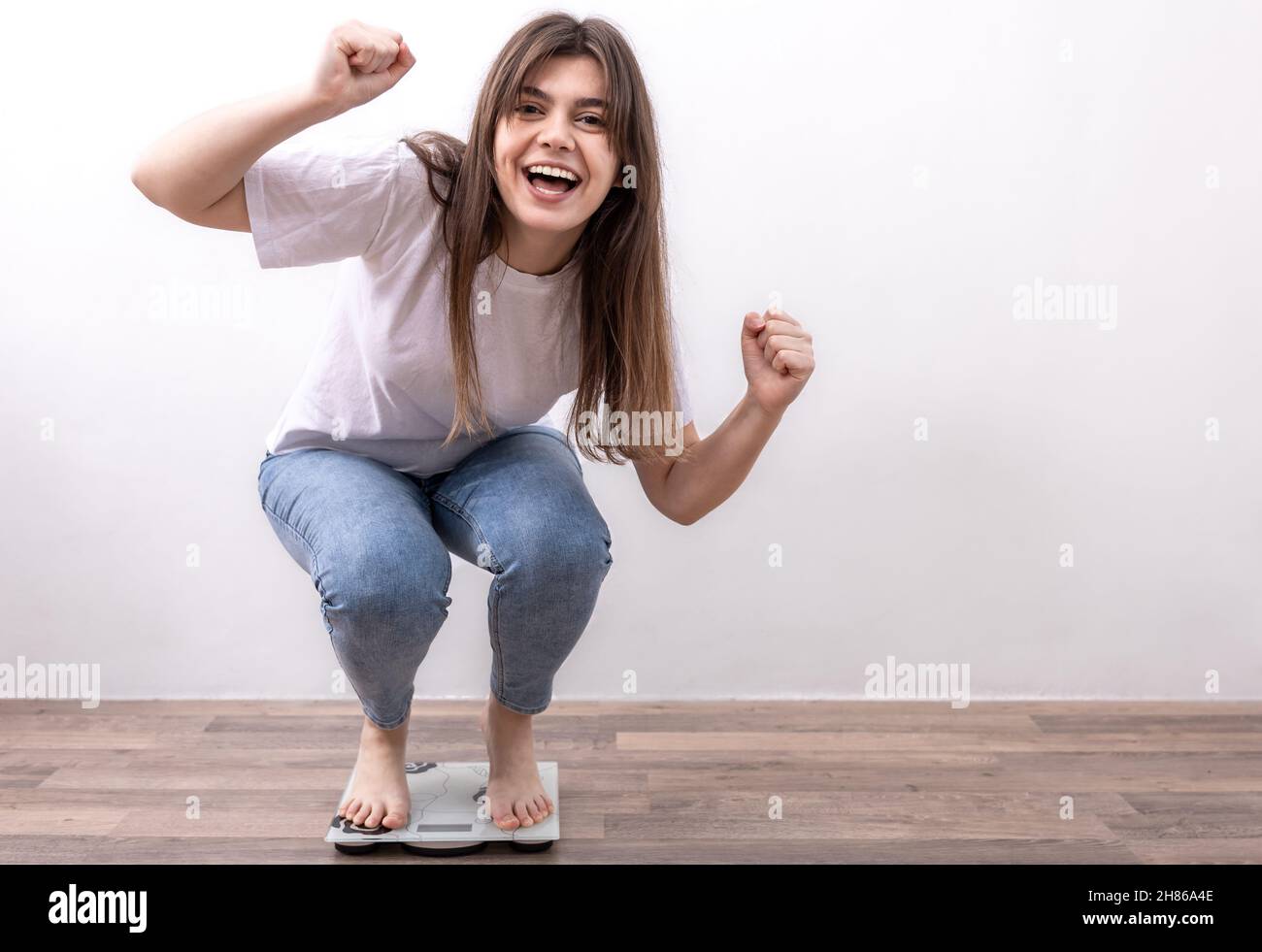 Happy Girl Is Weighed On The Scales At Home The Joy Of Losing Weight