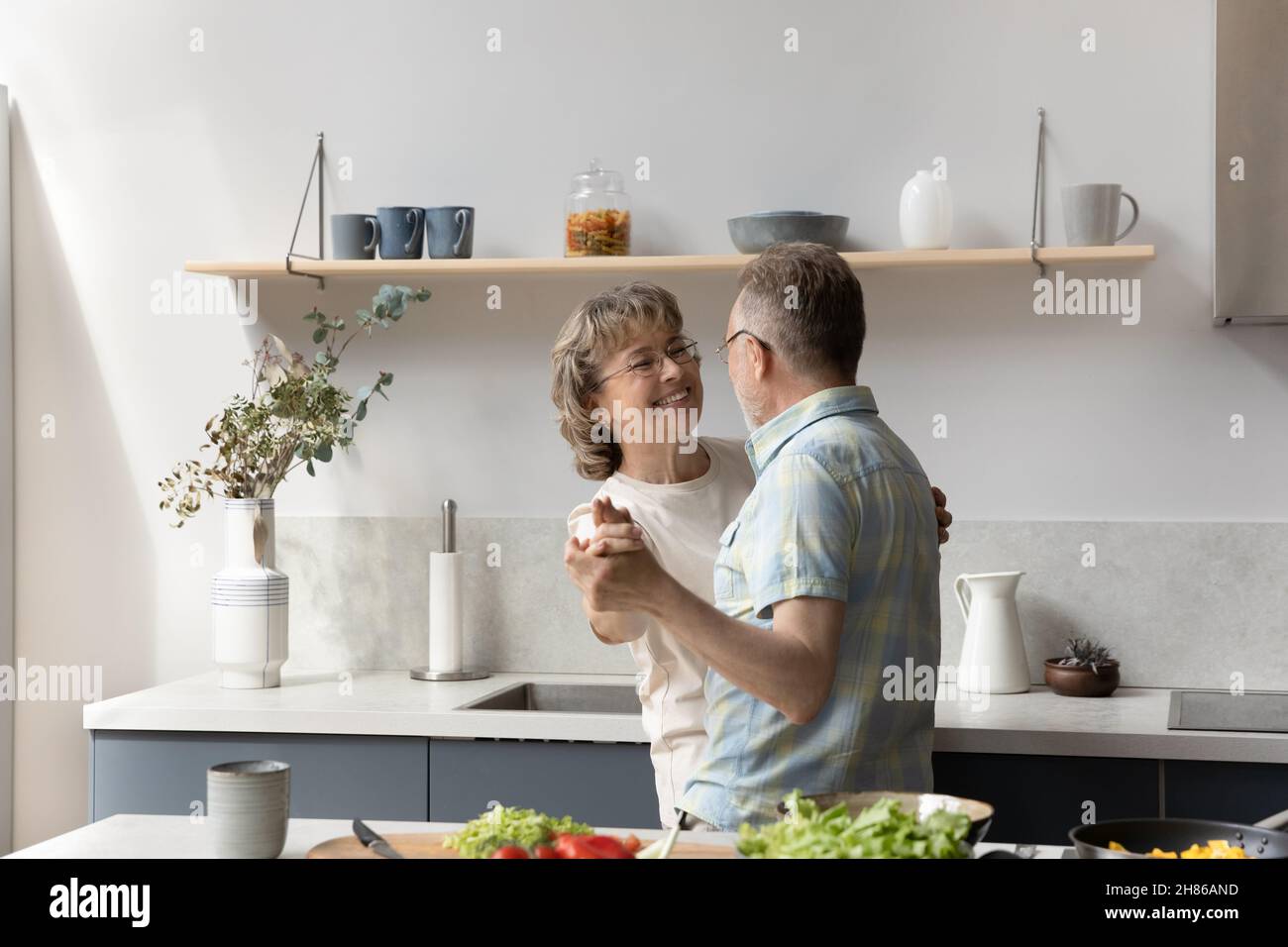 Happy elder couple having fun while preparing dinner Stock Photo