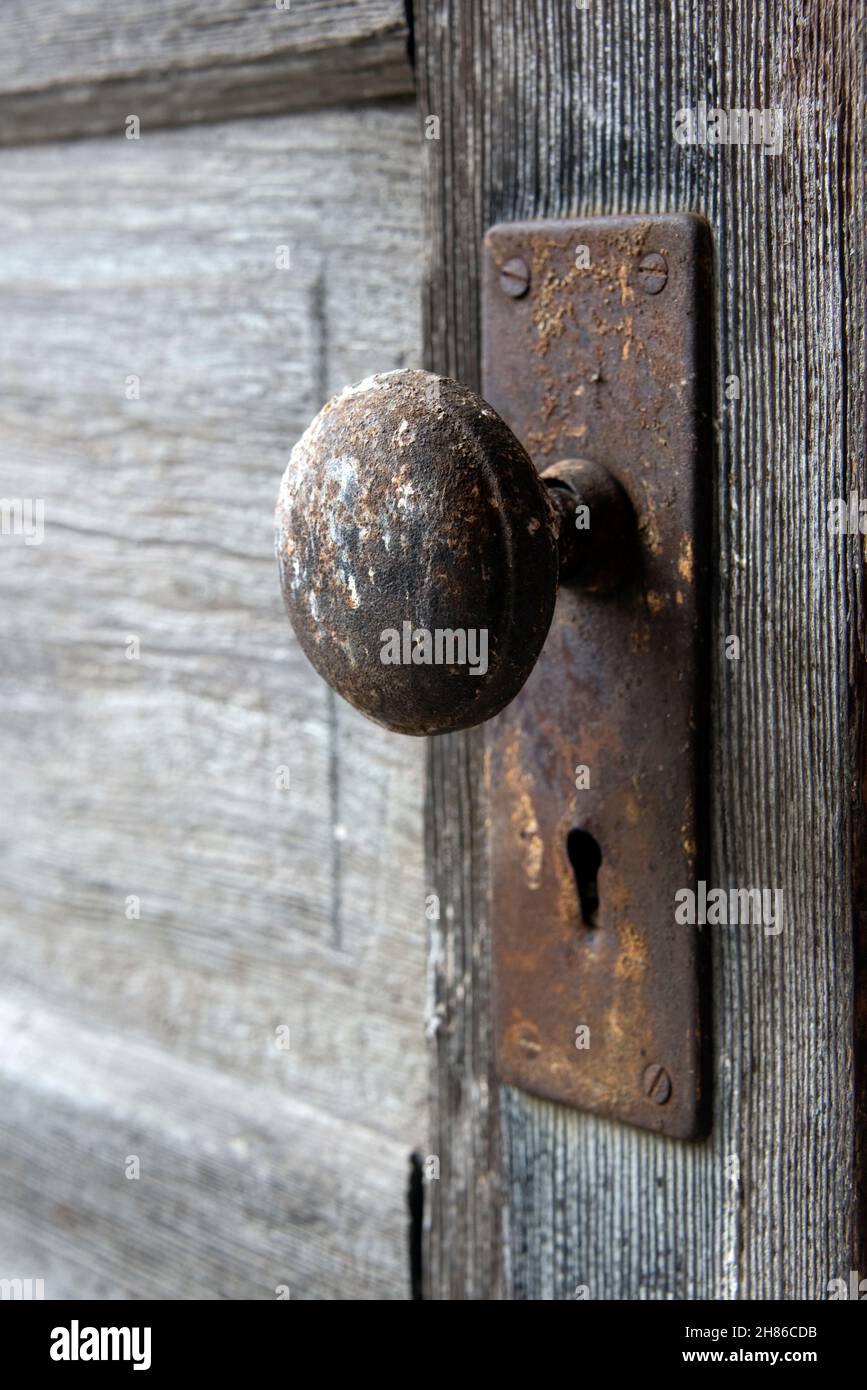 An old western entrance door and door knob, rusted with age. Stock Photo