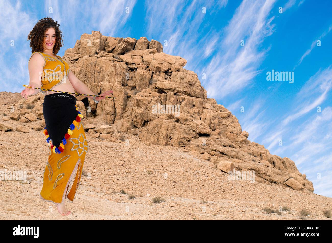 Egyptian style Baladi Belly dancer dances in the desert Stock Photo