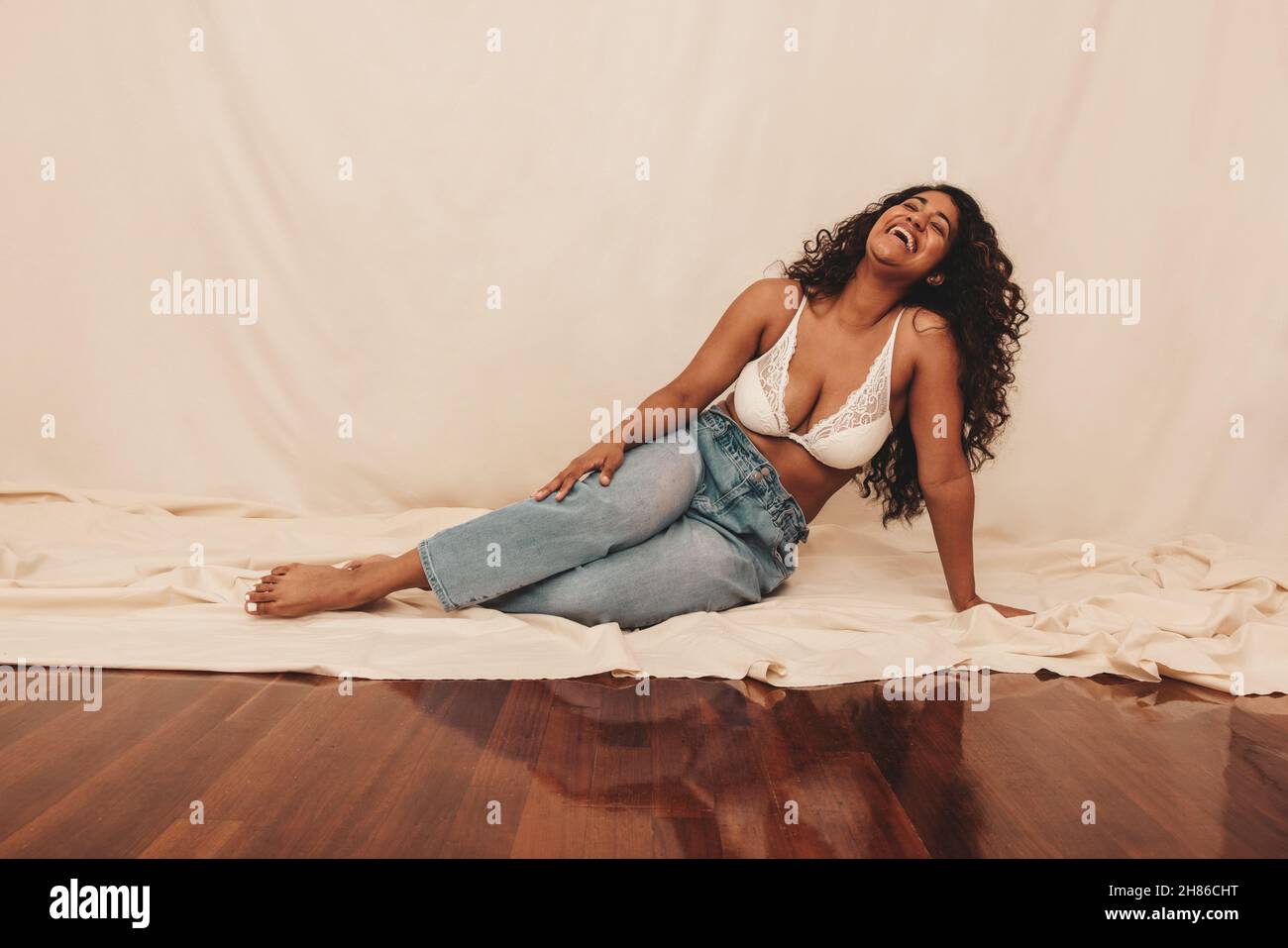 Blue jeans sweaters and a bra lying on a bed Stock Photo - Alamy